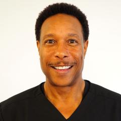 Dr. Demonbreun smiles while posing in front of a white background