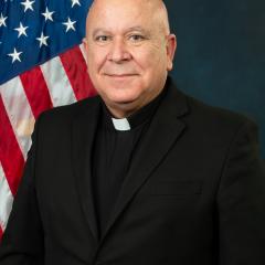 Dominic-Joseph Castro headshot with U.S. flag