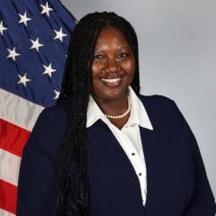 Physician and Provider Recruiter, Annie Luckey stands in front of an American flag. 