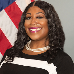 Woman standing in front of U.S. flag.
