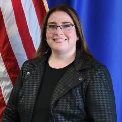 smiling female with the American flag in the background