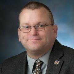 Timothy Rankin in front of a grey background