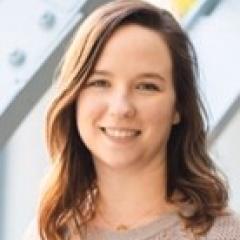 Woman with shoulder length brown hair, beige sweater.