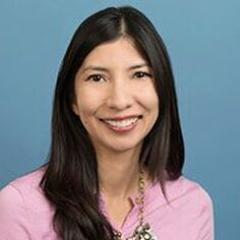 A woman with long black hair smiling for the camera.