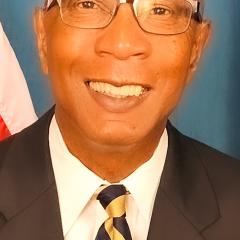 Portrait of a smiling man in a business suit and glasses.
