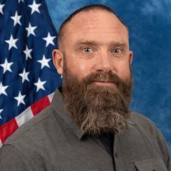 Rick Cooper official portrait in front of American flag.
