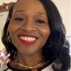 Portrait of a woman with black hair, red lipstick, and a white shirt smiling.