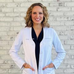 Woman in lab coat smiling