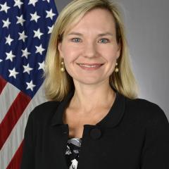 woman smiling in front of flag