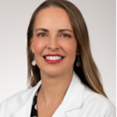 Smiling woman in white lab coat and red lipstick.