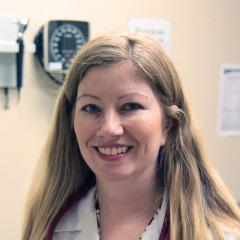 Smiling blonde woman in white lab coat and stethoscope.