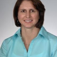 Photo of a woman in a blue shirt smiling at the camera.
