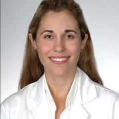 Portrait of a smiling woman in a white lab coat and shirt.