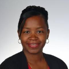 A woman with black hair, wearing a red shirt, black cardigan, and earrings, smiling for the camera.