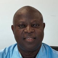 Photo of a bald man in a blue shirt smiling at the camera.