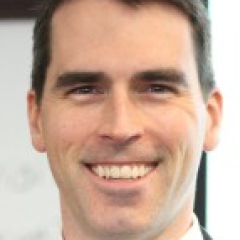 Portrait of a smiling man in a suit and tie.