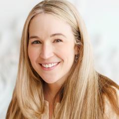 Headshot of smiling woman with long blonde hair against a white background.