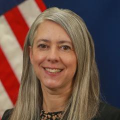 Christina Ryan official portrait in front of American flag.