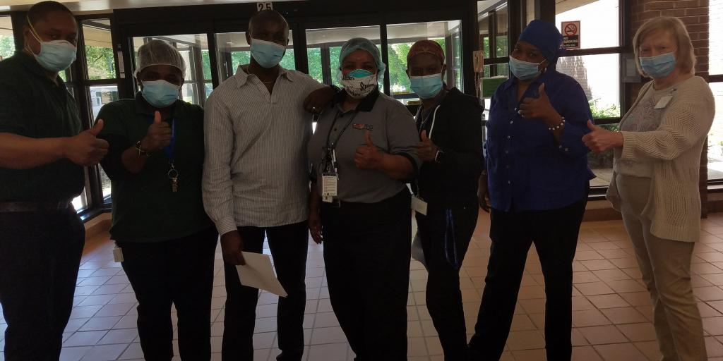 Group of people giving thumbs up. 