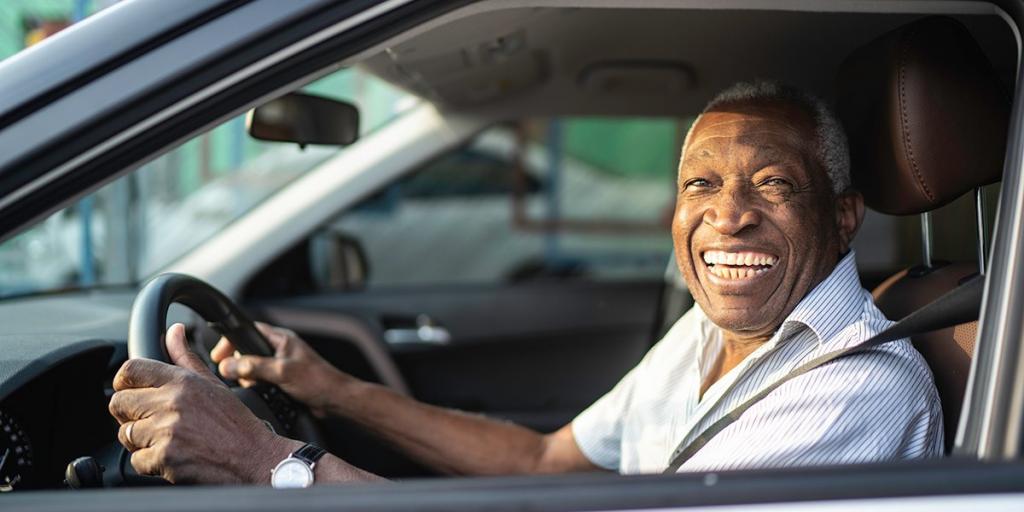 Man smiling inside car.