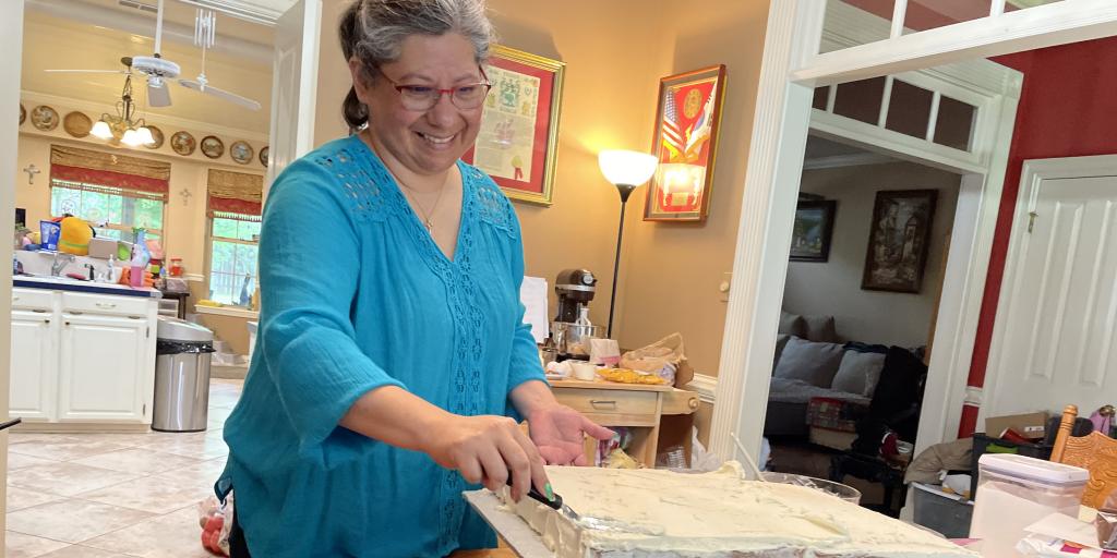 Jeanette Watson adds icing to the cake. She is preparing two cakes with different flavors and a few dozen cupcakes for a VA employee retirement. 