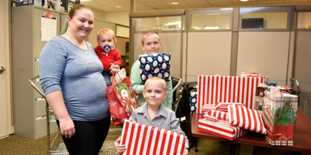 Laken Johnson, a dental technician with the Ralph H. Johnson VA Medical Center Dental Clinic, and her sons Carter, 10, Korbin, 6, and Logan, 1, donate gifts to the Voluntary Service Angel Tree program.