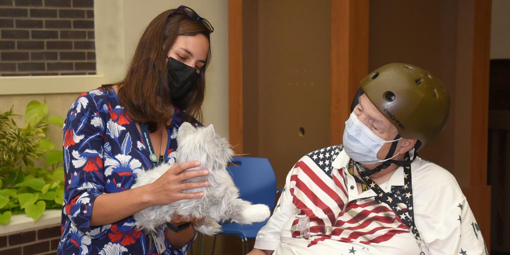 Dr. Vair presenting Robotic Cat to Veteran 