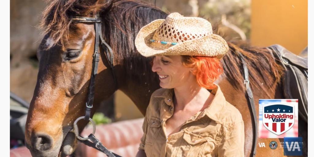 Woman wearing a cowboy hat next to a horse