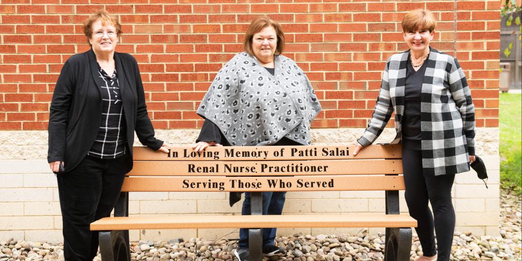 Three women behind a bench