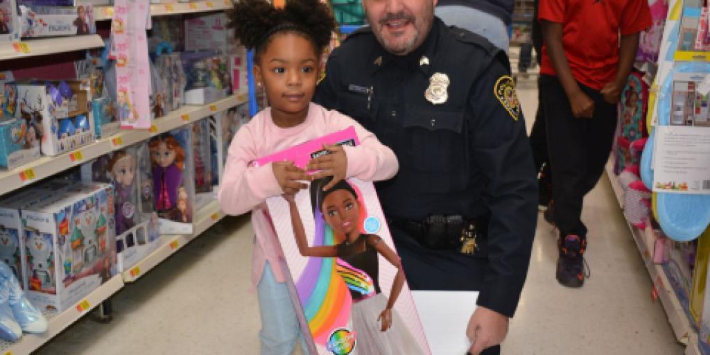 Police Sgt. Toy Williams was paired with a family of three at the Shop with a Cop event in Clarksville, TN. (Courtesy photo from Clarksville Now)