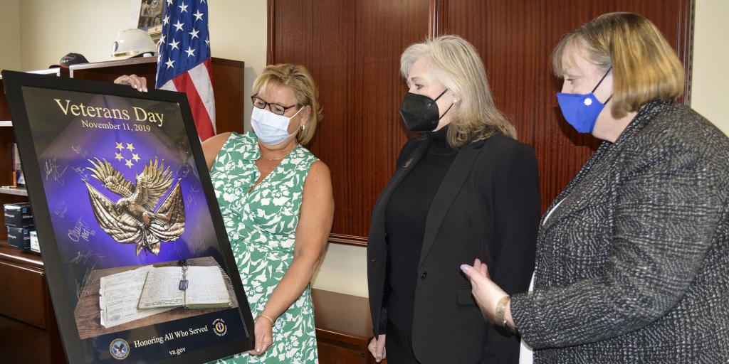 Three women look at a poster