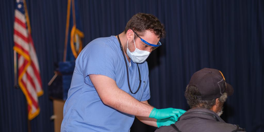Dunkin Adams, DMD, providing a dental screening to a Veteran.
