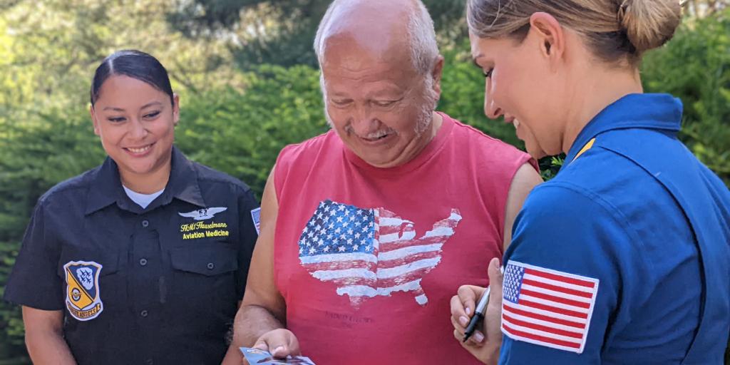 Lt. Cmdr. Monica Borza, flight surgeon with the Blue Angels, signs an autograph after meeting with Veterans Friday at the Milwaukee VA Medical Center. Borza and Hospital Corpsman 1st Class Amelia Hauselmann, left, talked with the group about their experiences with the Blue Angels.