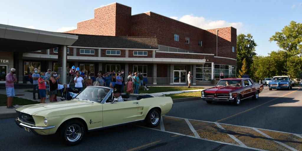 Cars, both old and new, circle Lebanon VAMC to honor a Veteran.