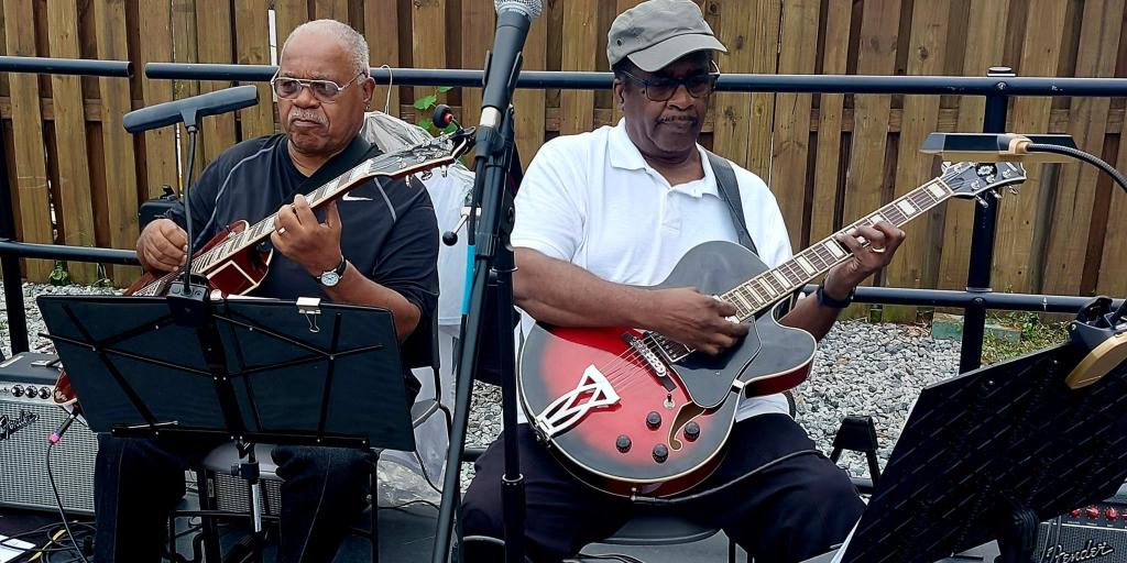 Army Veteran Harry Clark Walker, left, plays guitar with the Spirituality and the Arts Players (SAP) during their sophomore album release celebration on Sept. 10, 2022 at Joe's Movement Emporium in Washington DC. SAP is a musical group of DC VAMC staff and Veterans, formed under the DC VAMC's Spirituality and the Arts Program.