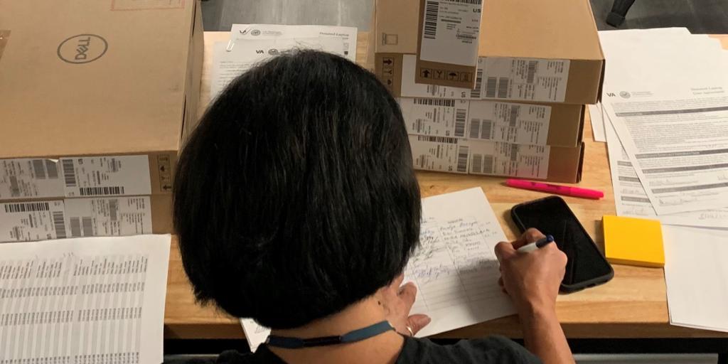 VA vocational rehab specialist Amalya Anneyan finalizes paperwork and assigns laptops to Veterans during the event.