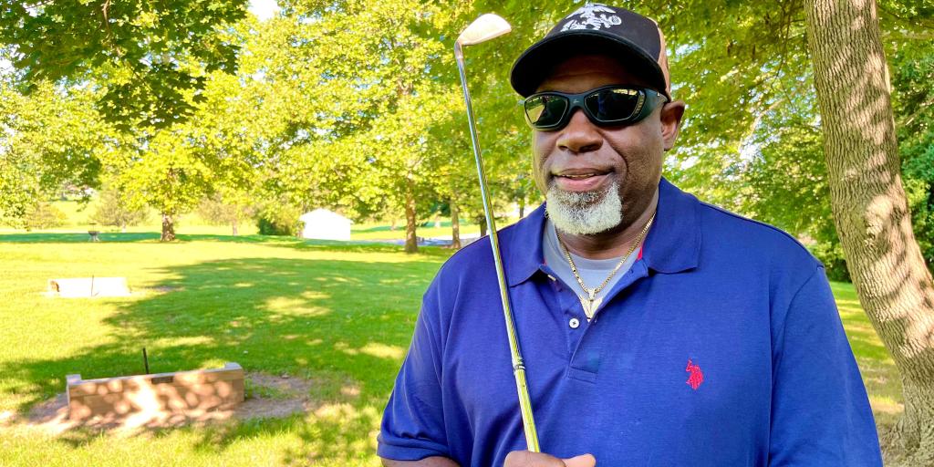 Photo of Paul White with a golf club.