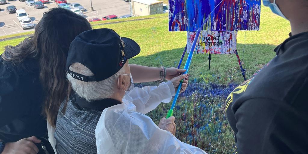 Veteran painting canvas outside