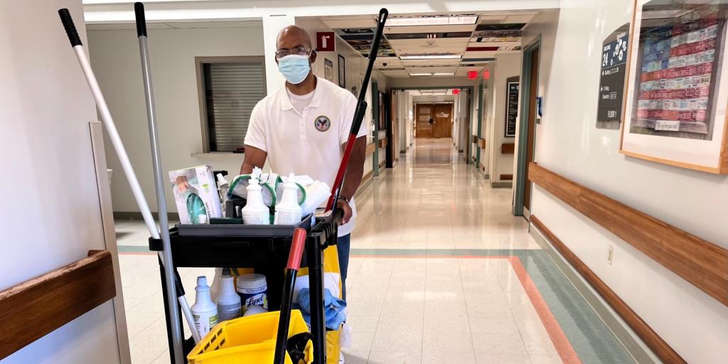 Former Army Veteran Shedrick Ward pushing a cleaning cart