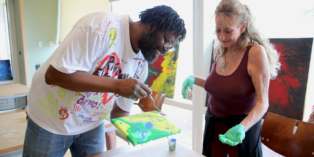 LCSW Larry D. Johns and Army Veteran Rosalind Jackson pouring paint during an art therapy group session at the OVAHCS Domiciliary.