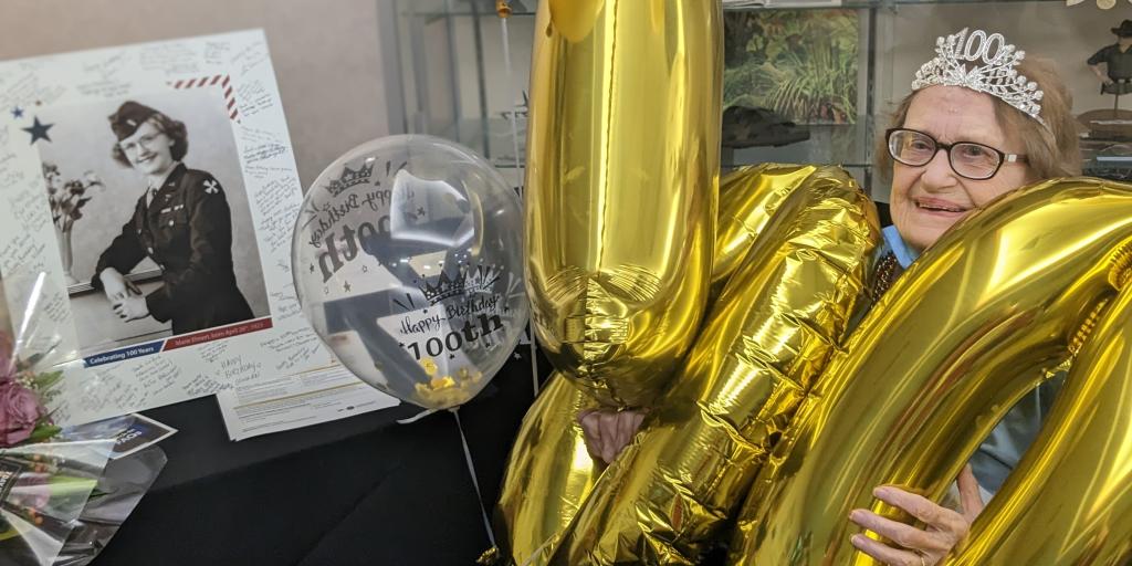 WWII nurse Veteran with 1,0,0, balloons and old 2nd Lt photo celebrates birthday