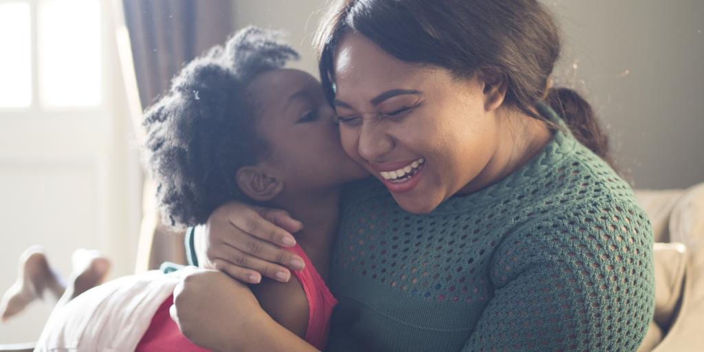 Smiling woman holding a small child.