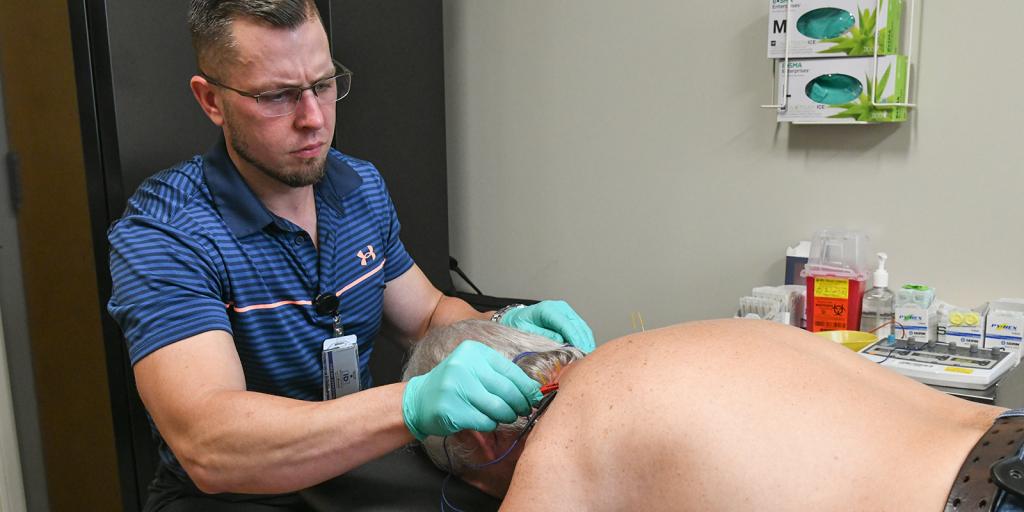A physical therapist works with a patient.