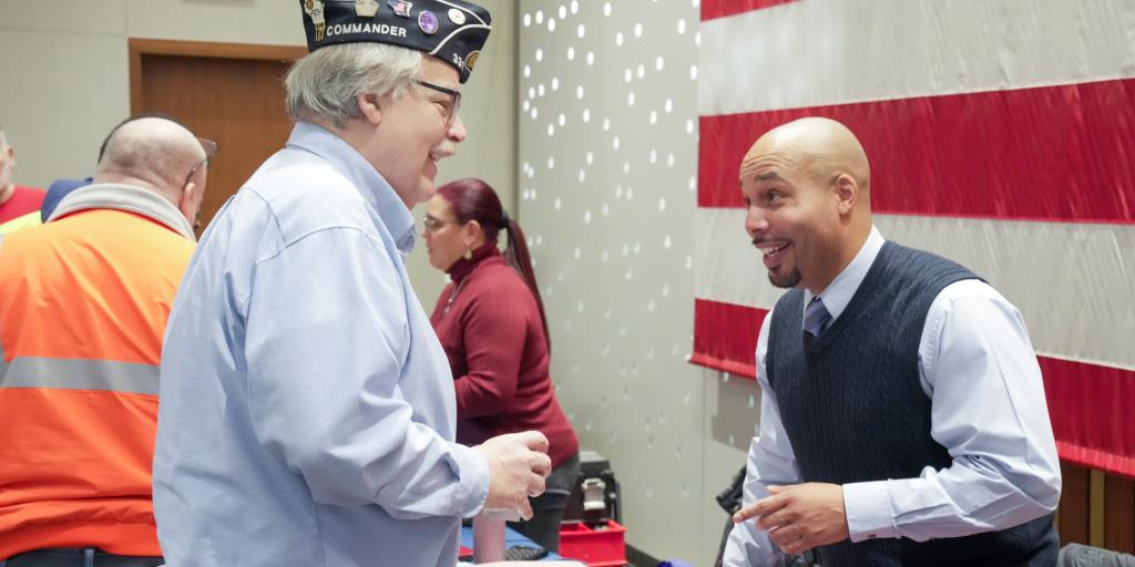 Milwaukee VA Chaplain Robert Allen talks with a symposium attendee.
