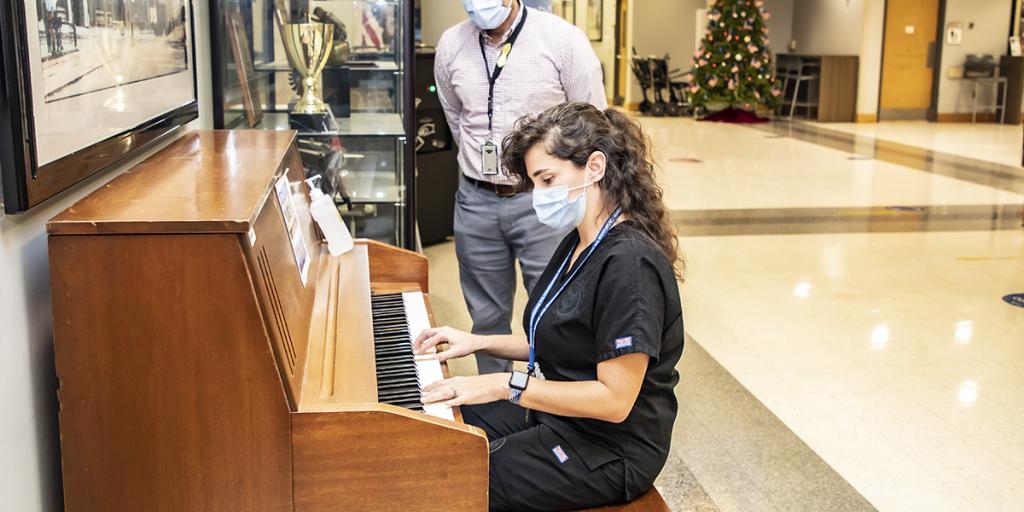 Katelynn Quinn, music therapist, plays the piano she worked to have placed in the Main Lobby of the Jack C. Montgomery VA Medical Center for Veterans with the help of Dr. Nathan Williams, Whole Health clinical director, the Whole Health team, and additional facility support. 