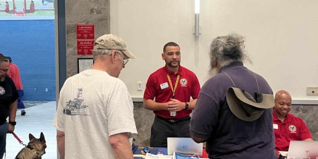 A VHA employee talks to two Veterans. 