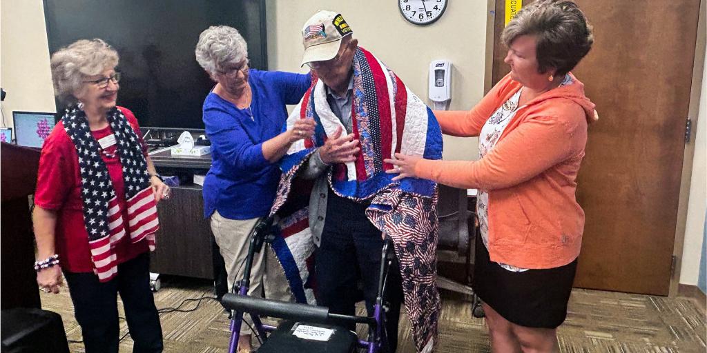Veteran has quilt wrapped around his shoulders