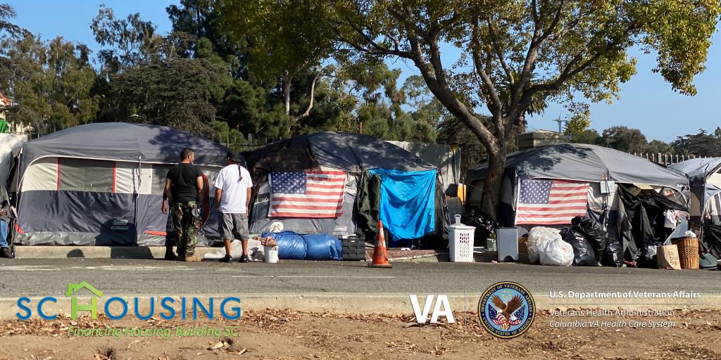 Homeless encampment of tents with U.S. flags posted on them. 
