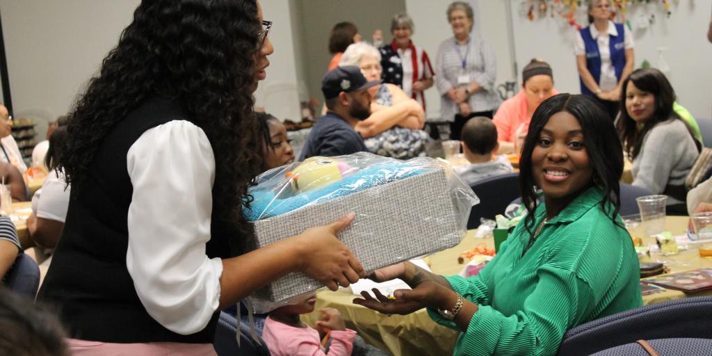 VA staff give a baby shower gift to a Veteran.