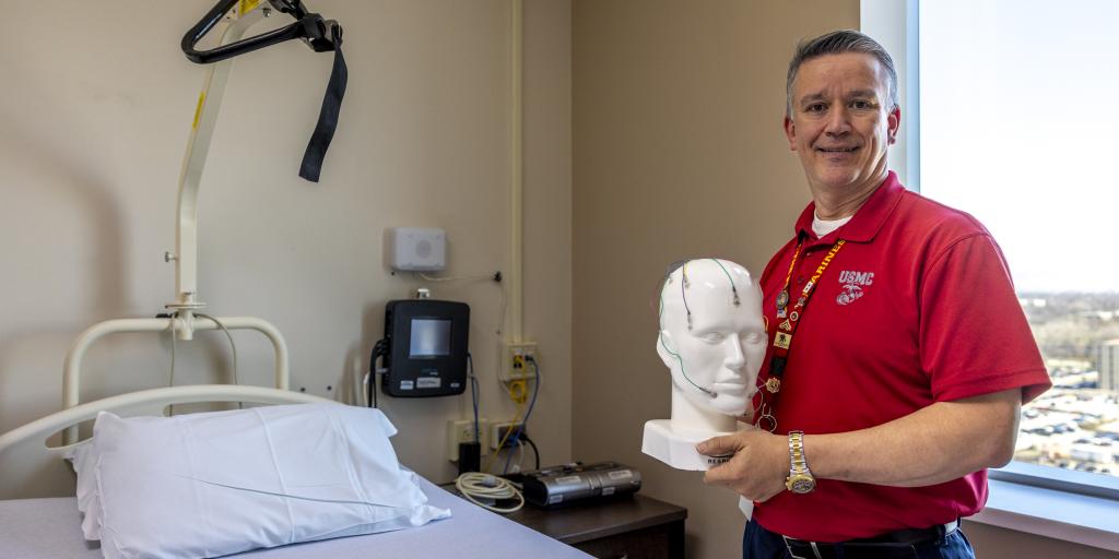 Jason Torres  holds a tool used in sleep studies to monitor Veterans' brain activity, teeth grinding, eye movements, snoring, and breathing patterns. 